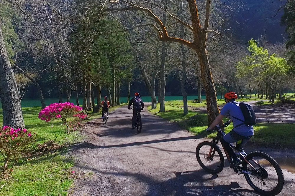 Ciclistas em uma trilha de terra junto aos lagos pitorescos de Sete Cidades, nos Açores, Portugal