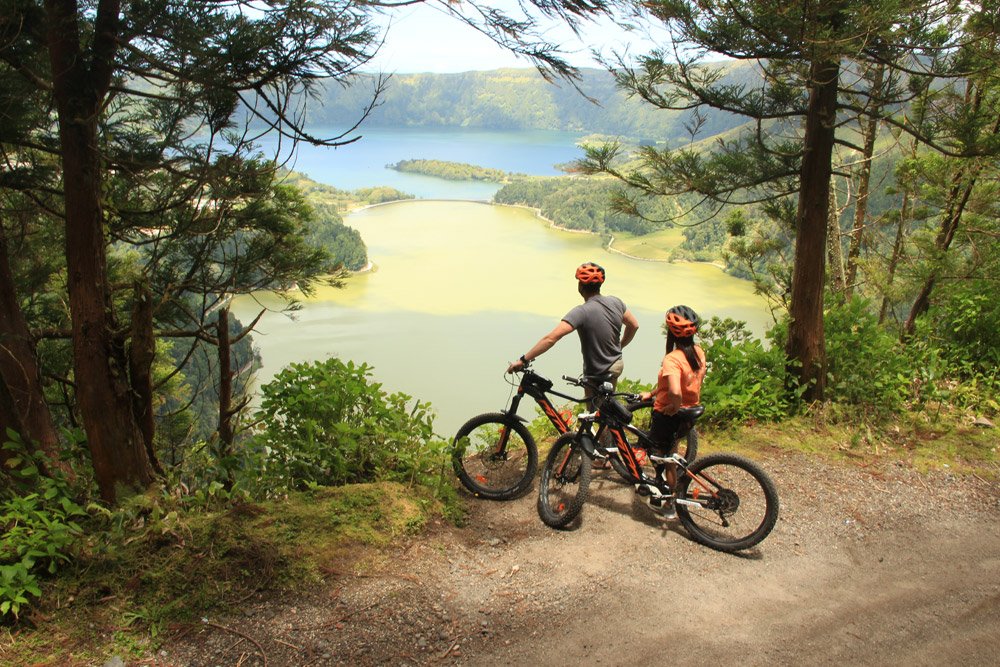 Ciclistas com vista para os lagos gêmeos da cratera vulcânica de Sete Cidades, na ilha de São Miguel, nos Açores
